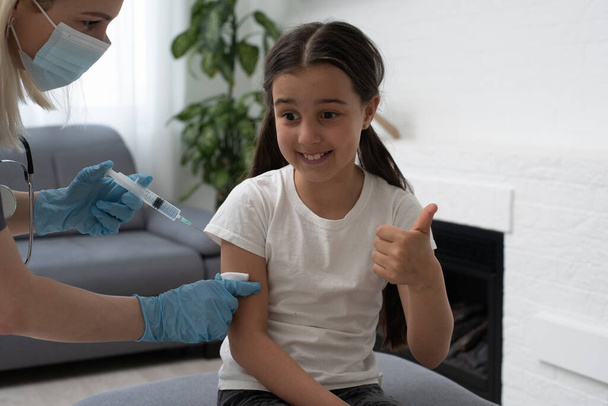 Krankenschwester verabreicht kleinen Patientin Impfspritze - Foto, Bild