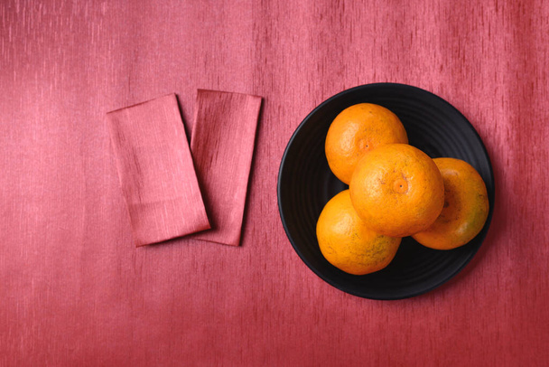 Orange fruit and red packet on red background, Chinese New Year, Lunar New Year - Foto, Imagem