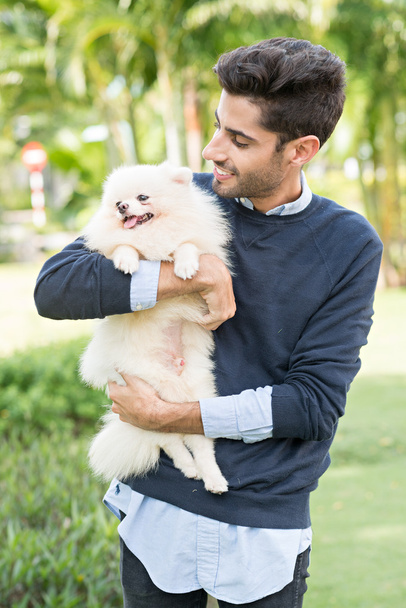 Hispanic man holding little dog - Photo, Image