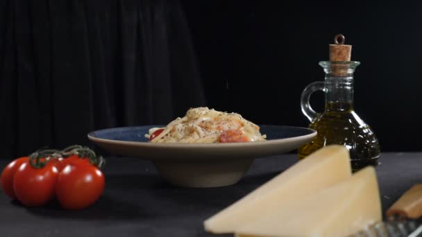 Šéfkuchař strouhá tvrdý sýr na čerstvě uvařené těstoviny z mořských plodů. Zpomal. Vertikální záběry. Nastrouhaný parmezán padající na špagety. Italská kuchyně. Podáváme jídlo v restauraci. typické italské jídlo. Full - Záběry, video