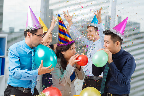 Business colleagues blowing up balloons - Fotó, kép