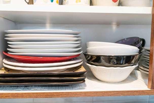 Stapel van platen in keuken cupborad thuis - Foto, afbeelding