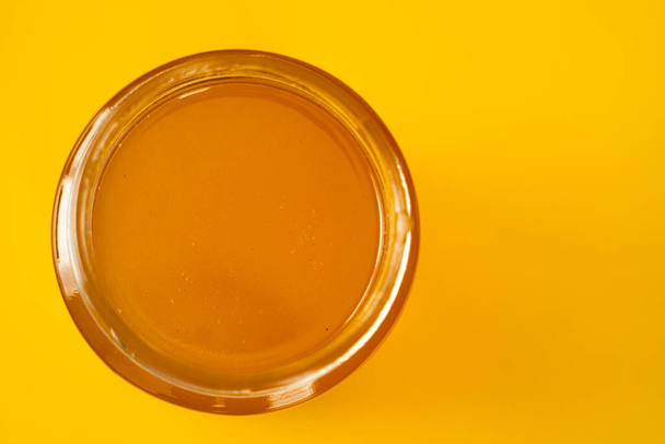 Джар органічного меду на жовтому тлі
 - Фото, зображення