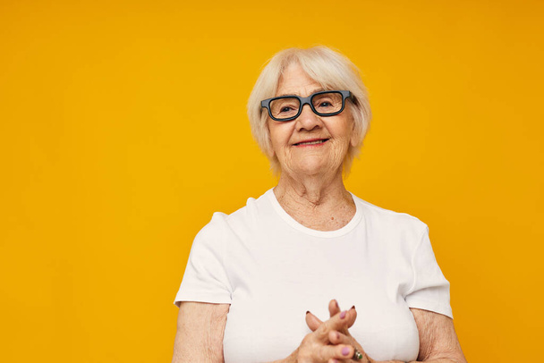 elderly woman vision problems with glasses yellow background - Fotoğraf, Görsel
