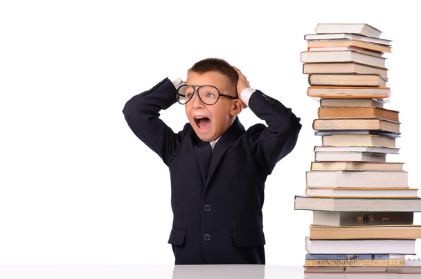 Schoolboy screaming near the huge stack of books - 写真・画像