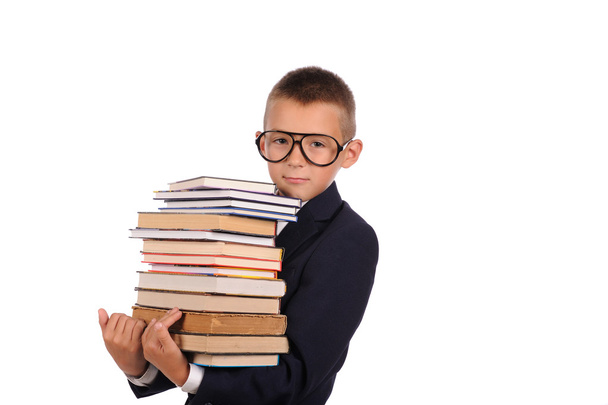 Schoolboy holding huge stack of books - Foto, immagini