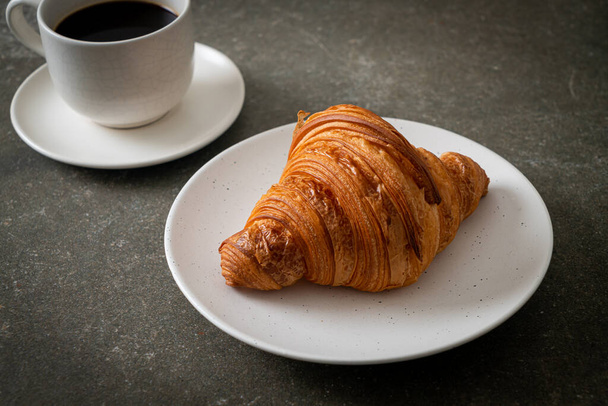 fresh croissant on white plate with black coffee - Foto, immagini