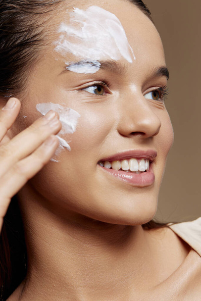 Nuori nainen kasvot naamio kerma puhdas iho kasvojen hangata lähikuva - Valokuva, kuva