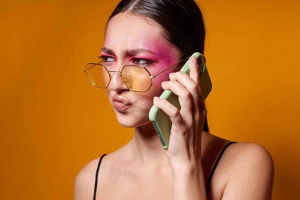 Beauty fashion female with glasses bright makeup posing black jersey talking on the phone cropped view unaltered - Фото, зображення