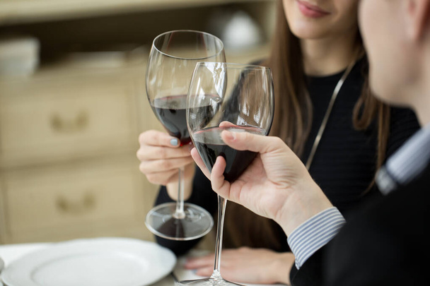Beautiful couple drinking wine in a restaurant. - Фото, изображение