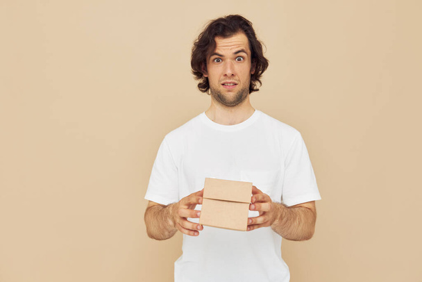 handsome man holding a cardboard small box in his hands - Foto, Imagen