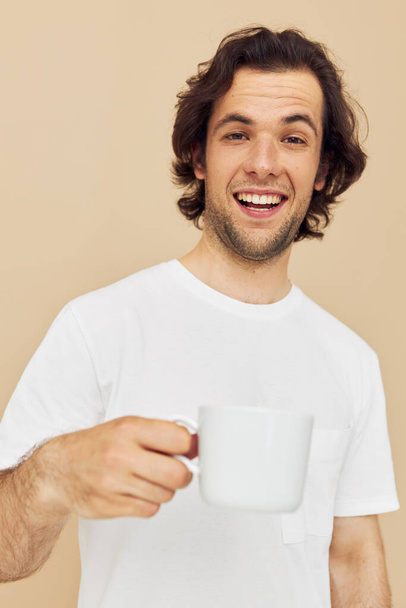Cheerful man with a white mug in his hands emotions posing isolated background - Foto, Imagem