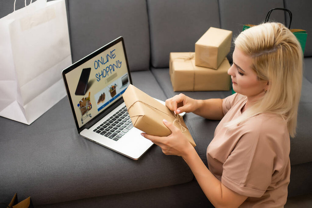 Mladá žena s laptopem a nákupními taškami doma. Černý pátek prodej - Fotografie, Obrázek