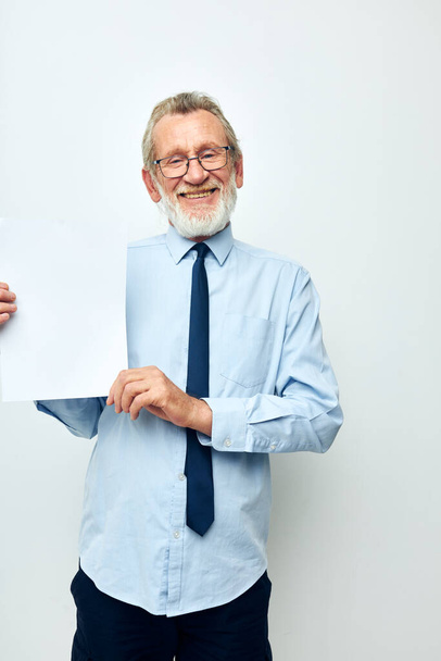 Portrait of happy senior man in a shirt with a tie copy-space sheet of paper cropped view - Photo, Image