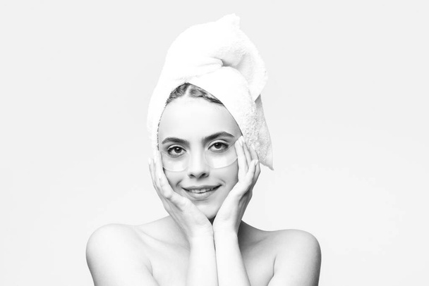 Kobieta nakłada przepaski na oczy. Portret piękna dziewczyna z ręcznikiem na głowie. - Zdjęcie, obraz