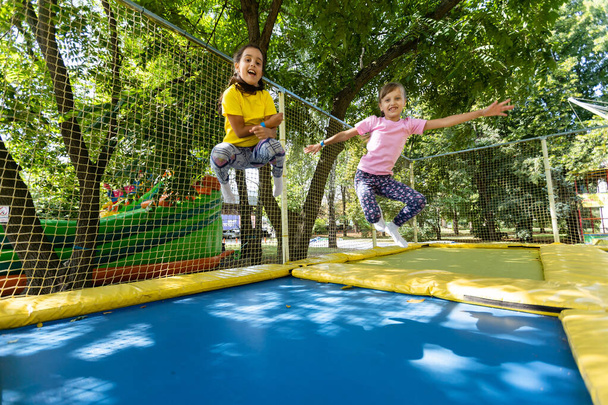 due ragazze che saltano su un trampolino in una giornata estiva. - Foto, immagini