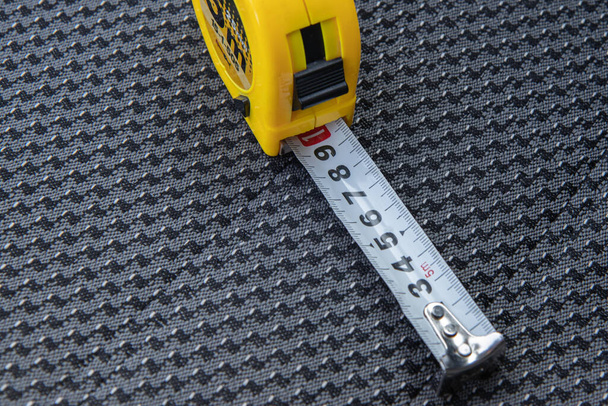 yellow tape measure laying on dark car sit - Foto, imagen