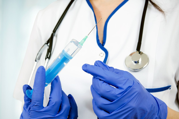 Woman doctor with gloves holding medical injection syringe and s - Foto, Bild
