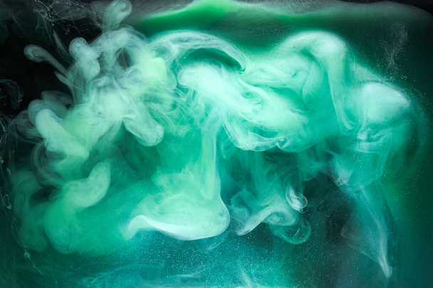 Green smoke on black ink background, colorful fog, abstract swirling emerald ocean sea, acrylic paint pigment underwater - Foto, Imagen