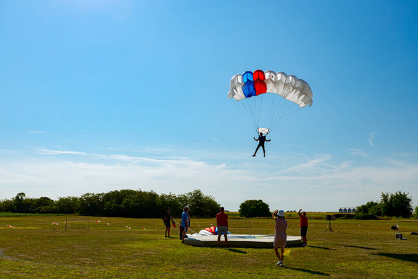 Paraquedistas abranda para uma aterragem precisa no local-alvo. Skydiving, deslizamento, salto de paraquedas. - Foto, Imagem