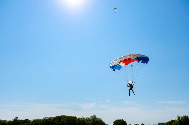 Paraquedistas abranda para uma aterragem precisa no local-alvo. Skydiving, deslizamento, salto de paraquedas. - Foto, Imagem