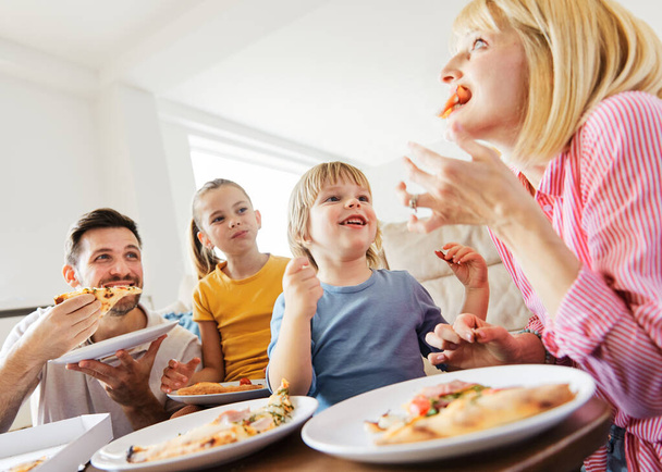 pizza family child food home eating son daughter mother father happy meal together lunch dinner man woman boy girl fun - Foto, imagen