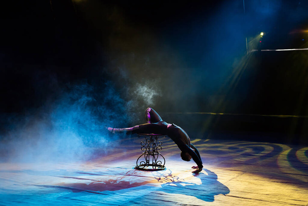 Acrobat performs a difficult trick in the circus - Zdjęcie, obraz