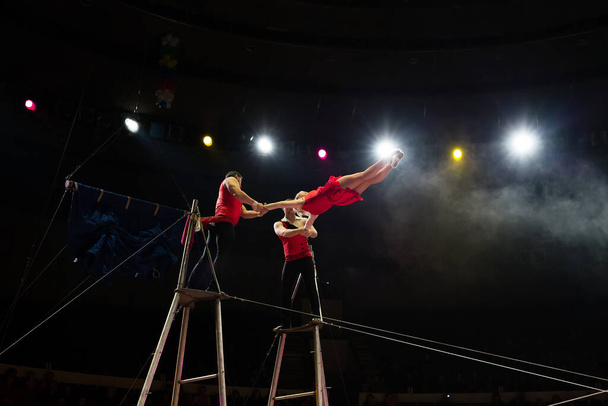 Bright performance of acrobats under the dome of the circus. - Foto, Imagem