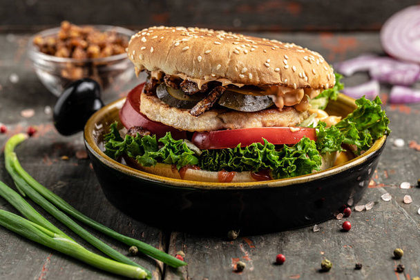Ev yapımı hamburger, ızgara et, sebze, ahşap arka planda sos. Fast food ve abur cubur kavramı. - Fotoğraf, Görsel