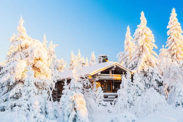 Beautiful winter landscape with wooden hut and snow covered trees in Lapland Finland - Zdjęcie, obraz