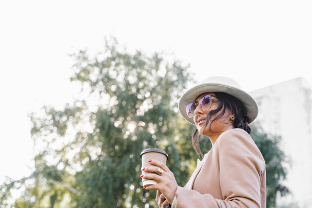 Close-up portret van zakenvrouw drinkt koffie buiten in het park - Foto, afbeelding