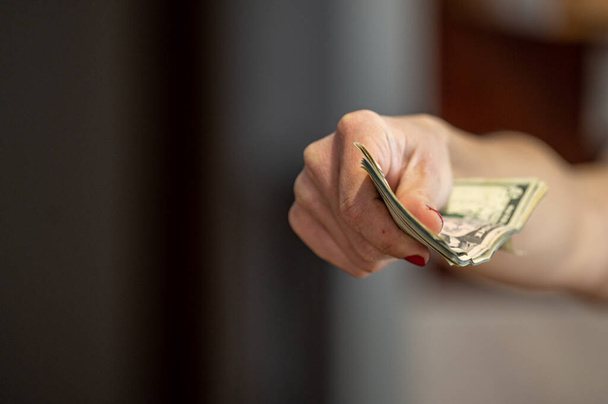 Closeup of woman hand giving money. - Фото, изображение