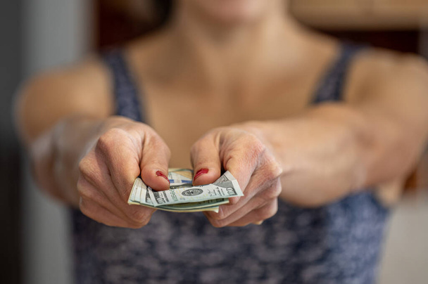Closeup of woman hand giving money. - Fotoğraf, Görsel