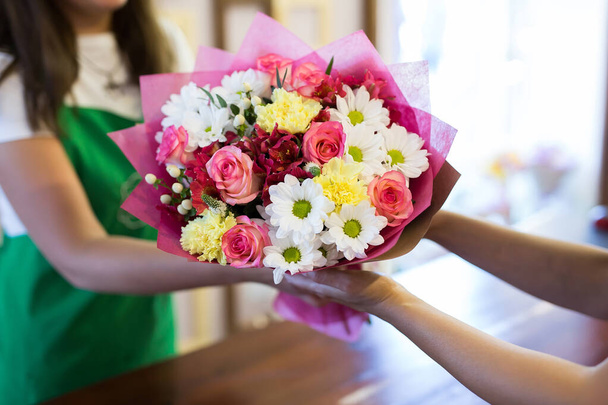 florist will give the client a beautiful flower bouquet. - Foto, immagini