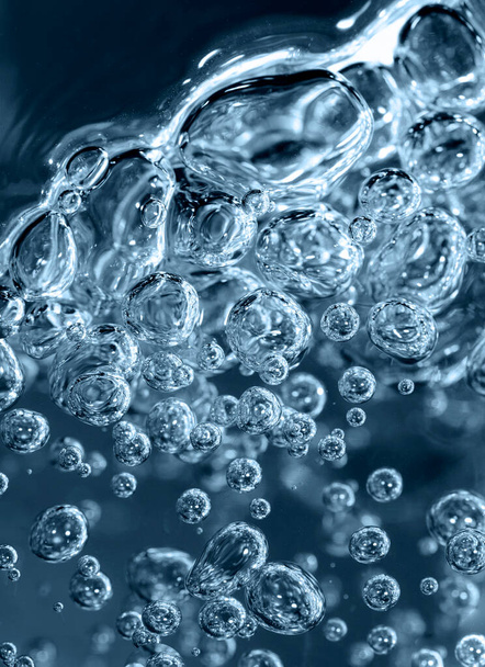 Nahaufnahme transparenter Luftblasen im Wasser in Blautönen. - Foto, Bild