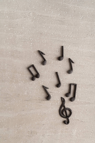 Treble clef and musical notes on beige background. Violin key. Vertical frame. Top view - Photo, Image