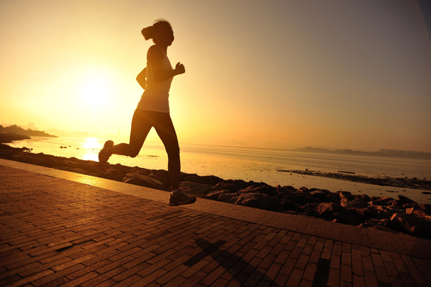 Бігун біжить на узбережжі. жінка фітнес силует схід сонця біг тренування концепція оздоровлення
. - Фото, зображення