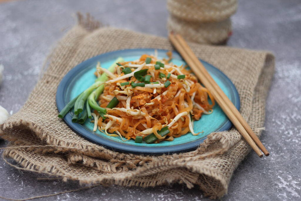 Thai food Pad Thai Thai stir-fried noodles (national dish) served in blue plate. - Photo, Image