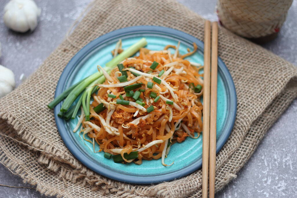 Thai food Pad Thai Thai stir-fried noodles (national dish) served in blue plate. - Photo, Image