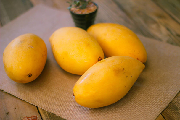 Kultainen mango on sijoitettu lattialle puinen pöytä Thaimaassa. - Valokuva, kuva