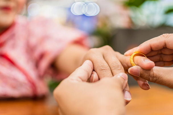 Um homem usa um anel de noivado para pedir em casamento num centro comercial que exprime o seu amor com alegria. O conceito para Dia dos Namorados, Casamento, Casamento, Casal, Casal. Fechar, fundo embaçado - Foto, Imagem