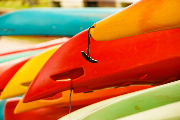 Colorful kayaks in stack on water shore. Holidays and active lifestyle. - Фото, зображення
