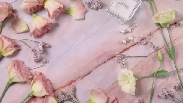 Mano pone AHORRE LA FECHA tarjeta en una mesa de mármol cerca de flores de color rosa de cerca  - Imágenes, Vídeo