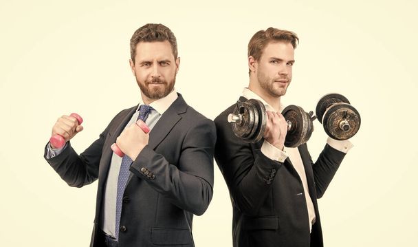 Strong and weak businessmen do dumbbell workout with hand weights, business competition - Photo, Image