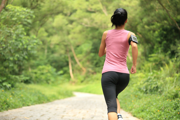 Woman running at forest trail - 写真・画像
