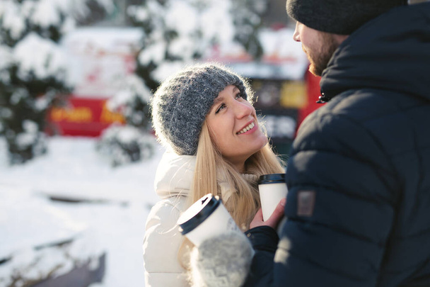 Close-up portrait of a happy couple: men and women hugging and laughing in a winter snow park - 写真・画像