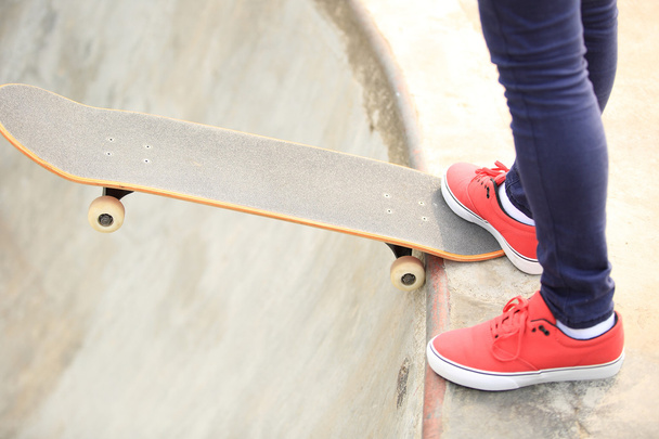 Young woman legs skateboarding at skatepark ramp - Fotografie, Obrázek