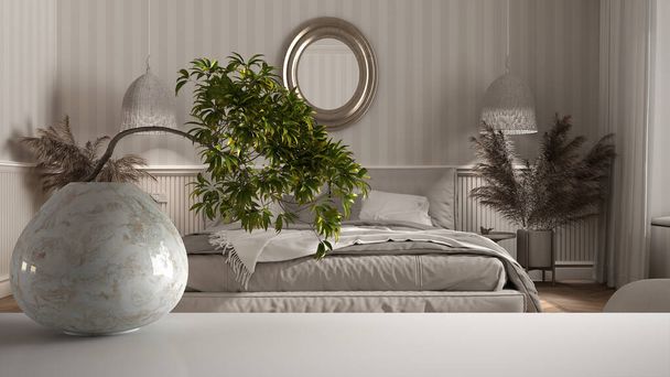 Estante de mesa de estera blanca con jarrón de mármol redondo y bonsái en maceta, hojas verdes, dormitorio clásico con papel pintado y carpintería, cama doble con almohadas y decoraciones, diseño interior - Foto, Imagen