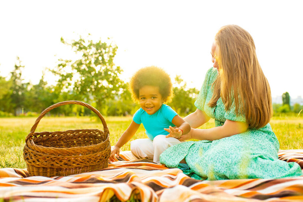 mothers day celebration concept little girl with afro curly hair with mother having great time at picnic - Фото, зображення