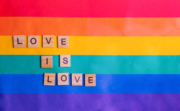 Love is love inscription with rainbow Flag. The concept of rainbow love. Human rights and tolerance. Poster, postcard, banner and background. - Φωτογραφία, εικόνα